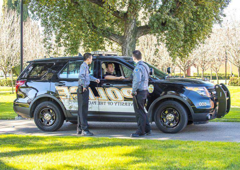 public safety employees gather by a vehicle